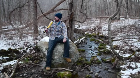 Lumberjack Sits by a Stream Video stock 58132587