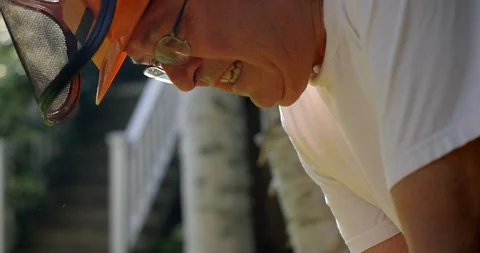 Lumberjack starting chain saw with pull string - close up on face Stock Footage 120655393