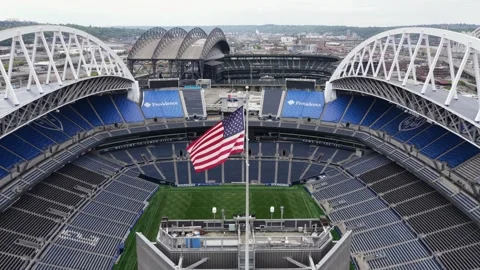 Lumen Field stadium in Seattle reveals empty blue seating bowl, American flag Stock Footage 337691925