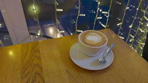 Luminous cozy setting. Warm beverage with ambient lighting. Cinematic urban Stock Footage 330291059
