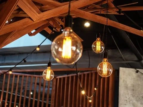 Luminous decorative lanterns hanging under a decorated wooden ceiling with Stock Photos