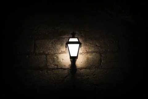 A luminous lantern on a stone wall Foto stock