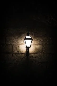 A luminous lantern on a stone wall Stock Photos