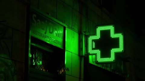 Luminous pharmacy cross sign changing patterns in the nighttime city Stock Footage 305567137