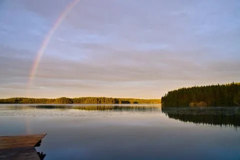 Luminous Rainbow Over Calm Forest Lake Stock Photos
