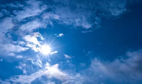 Luminous sun surrounded by clouds Stock Photos