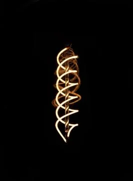 Luminous thread of a retro Edison lamp on a dark background Stock Photos
