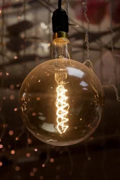 Luminous thread of a retro Edison lamp on a dark background Stock Photos