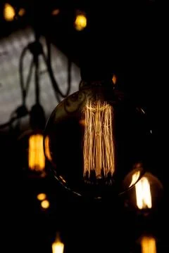 Luminous thread of a retro Edison lamp on a dark background Stock-Fotos