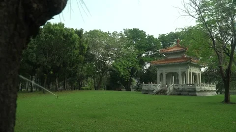 Lumphini Park Temple - Pan left to right from behind tree Stock Footage 149165306