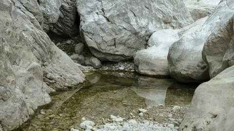 Lumps of rocks in water with reflection, Gorrori canyon 스톡 사진