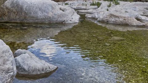 Lumps of rocks in water with reflection, Gorrori canyon Stock Photos