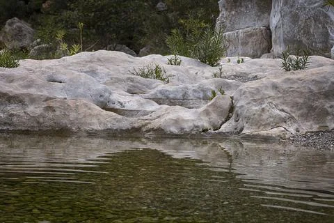 Lumps of rocks in water with reflection, Gorrori canyon 스톡 사진
