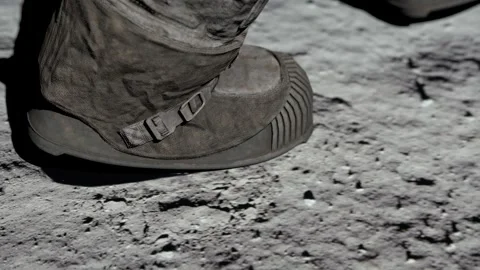 Lunar astronaut walking on the moon's surface and leaves a footprint in the luna Stock Footage 247444725