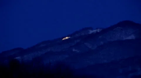 The lunar disk gradually vanishes coming for a blue evening hill Видео 12320404