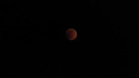 Lunar eclipse 2022 red moon sun clouds changing color Stock Footage 199947701