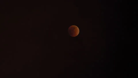 Lunar eclipse 2022 red moon sun clouds changing color Stock Footage 199949808