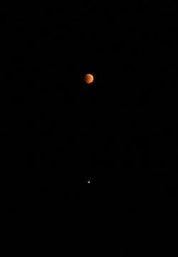 Lunar eclipse and Mars on a black background Stock Photos