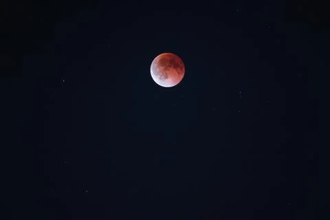 Lunar eclipse with blood moon phenomenon visible in the dark sky, unique Stock Photos