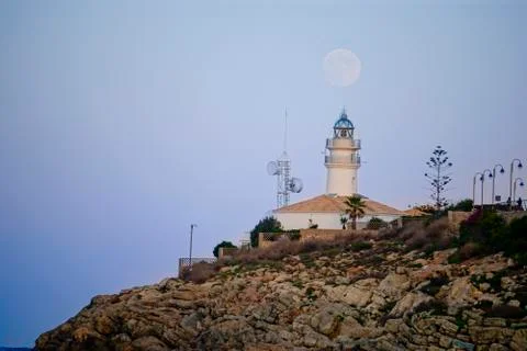 Lunar eclipse over the lighthouse of cullera Stock Photos