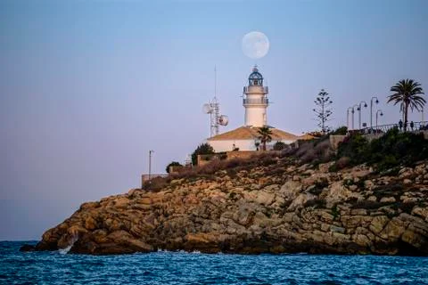 Lunar eclipse over the lighthouse of cullera Stock Photos