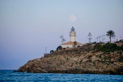 Lunar eclipse over the lighthouse of cullera Stock Photos