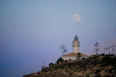 Lunar eclipse over the lighthouse of cullera Stock Photos