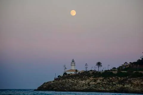 Lunar eclipse over the lighthouse of cullera Stock Photos