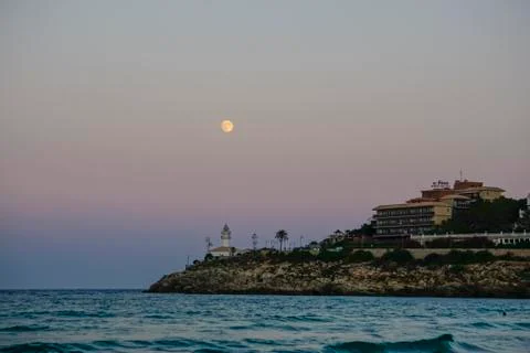 Lunar eclipse over the lighthouse of cullera Stock Photos