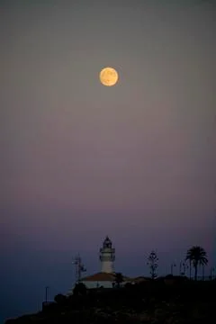 Lunar eclipse over the lighthouse of cullera Stock Photos