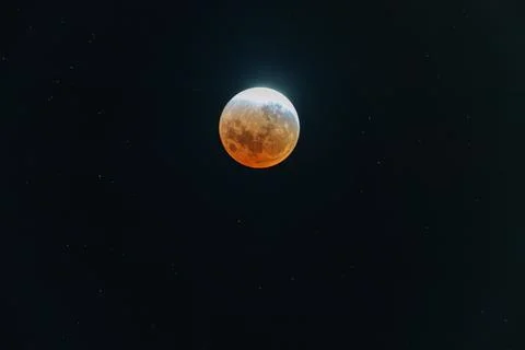 Lunar eclipse phase or blood moon as sun start to glow  behind from New Zea.. Stock Photos