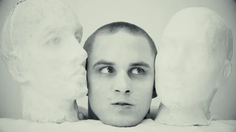 Lunatic between two heads made of plaster Stock Footage 67599799