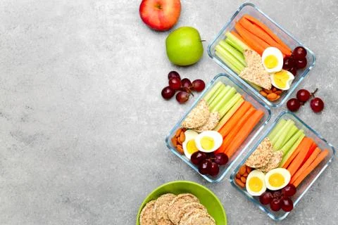 Lunch boxes with healthy snacks, overhead view Stock Photos