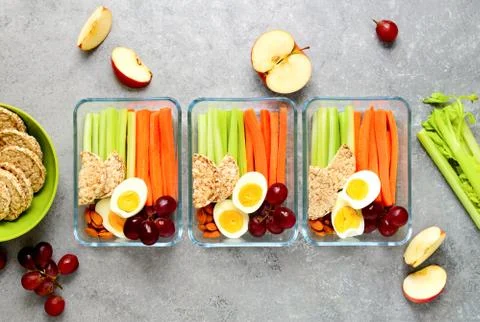 Lunch boxes with healthy snacks, overhead view Stock Photos