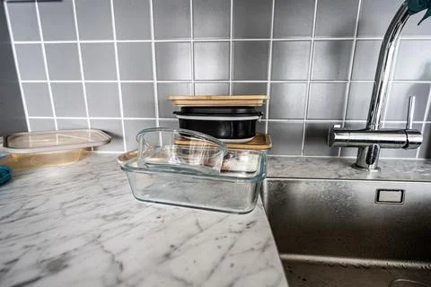 Lunch boxes by a kitchen sink. Stock Photos