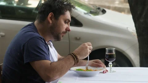 Lunch break - young man on lunch break eats spaghetti and drinks wine Stock Footage 220550077