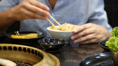 Lunch at a Chinese restaurant. A man eats rice with vegetables chopsticks. 4k Stock Footage 86489925