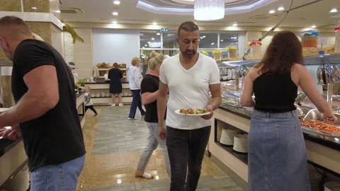 Lunch or dinner at the buffet restaurant. The guests place food on their plat Vídeos de archivo 202247180
