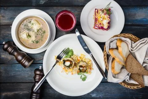 Lunch set. Fish rolls with rice, soup and traditional russian salad with herring Stock Photos