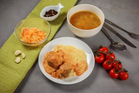 Lunch set made of mashed potatoes, meatballs, soup, carrot and cheese salad. Stock Photos