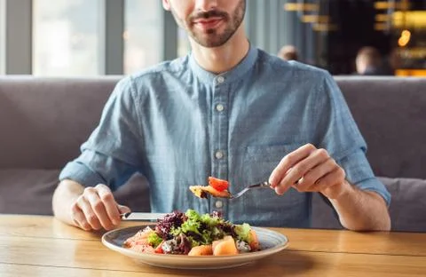 Lunch Time. Guy sitting at table eating salmon salad smiling happy close-up Stock Photos