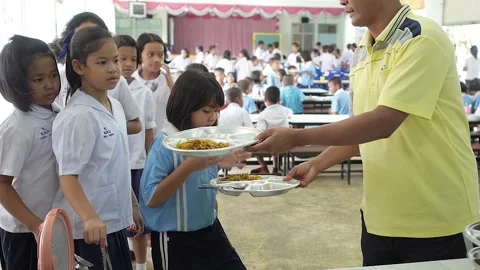 Lunch time Thai primary students in canteen teacher give plate with food Stock Footage 156752036