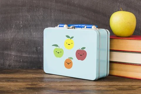 Lunchbox near stack books apple Stock Photos