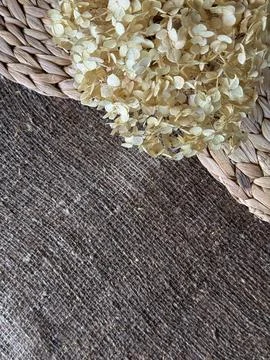 Lush dried hydrangea flower on damp linen burlap and water hyacinth placemats Foto stock
