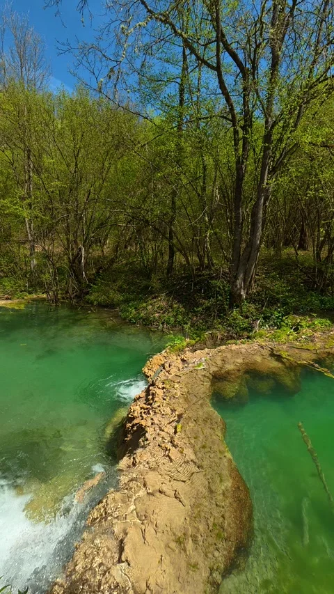 Lush forest surrounds emerald pool. Vertical POV, Balkan, Eastern Europe Stock-Footage 333700385