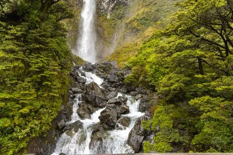 Lush Forest Waterfall Cascading Over Dark Rocks Stock Photos