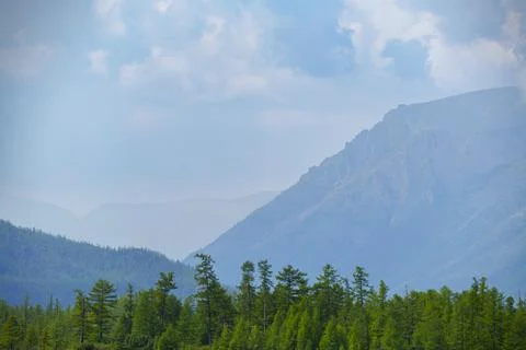 Lush forested mountains under a cloudy sky Stock Photos