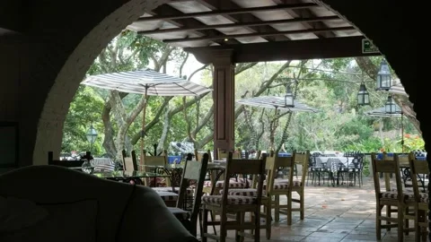 Lush garden restaurant empty tables and archway Video stock 206098357
