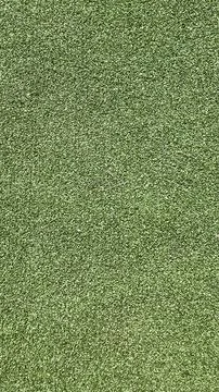 Lush green artificial turf covering a sports field in bright daylight at a .. Stock Photos