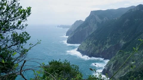 Lush green cliffs overlooking dramatic ocean waves Vídeos de archivo 333695920